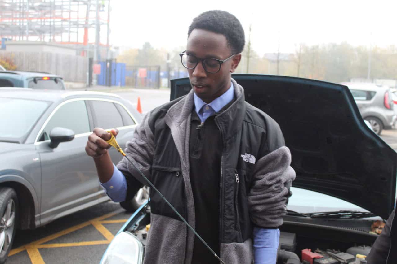 A Didsbury Sixth Form student uses an engine oil dipstick